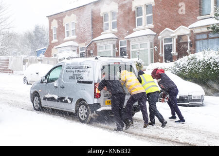 Menschen helfen Drücken klemmt Auto im Schnee Stockfoto