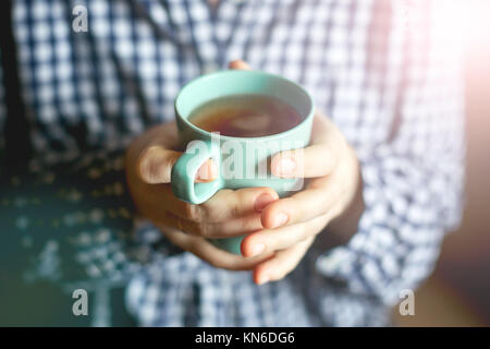 Frauen Hände halten eine Tasse Tee, Toning Stockfoto