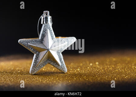 Golden glänzt mit Silver Star auf schwarzem Hintergrund, Weihnachtskarte Stockfoto