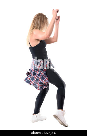 Seitenansicht des blonden jungen weiblichen Jazz Dancer tanzen mit Arme angehoben, während Sie auf der Suche. Voller Körper Länge Porträt auf weißem Hintergrund. Stockfoto