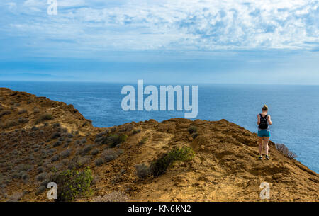 Eine junge Frau in einem kleinen Rucksack Spaziergänge durch den Atlantischen Ozean in Teneriffa, Spanien Stockfoto