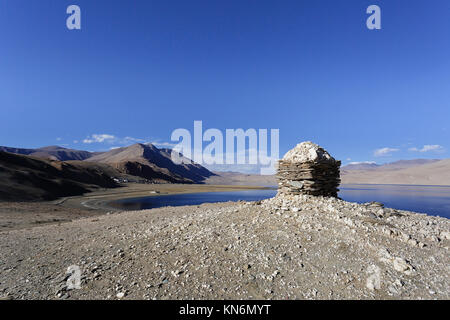 Ein steinernes Denkmal von te See Tso Moriri, mit der Ortschaft Karzok in der Rückseite, Ladakh, Jammu und Kaschmir, Indien. Stockfoto