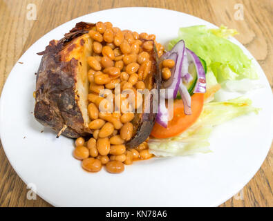 Billiges gesundes Mittagessen Ofenkartoffeln, gebackenen Bohnen und Salat Stockfoto