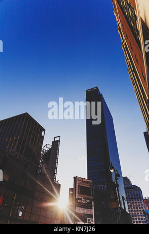 NEW YORK, USA - 7. September 2017: Sunflare zwischen Wolkenkratzern in Midtown Manhattan in der Dämmerung Stockfoto