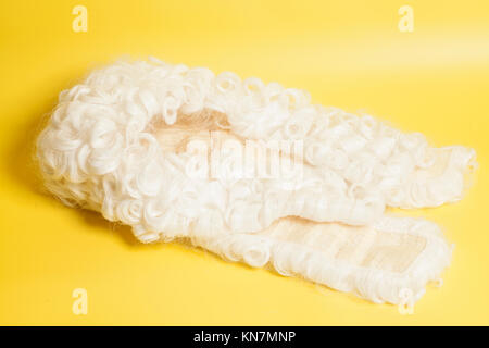 Perücke auf gelbem Hintergrund beurteilen. Stockfoto