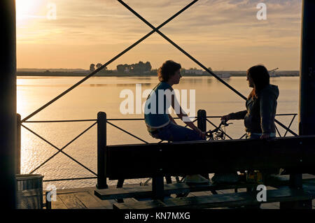 Mineral Pier auf der Odiel river (auch "Muelle de Riotinto) bei Sonnenuntergang, zwei Mädchen sprechen, Huelva, Andalusien, Spanien, Europa Stockfoto