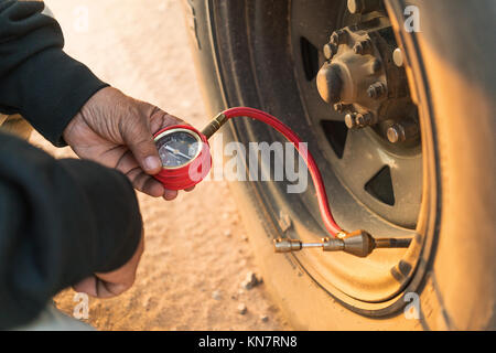 Mann messen Reifendruck mit Zähler. Jeep 4x4. Stockfoto