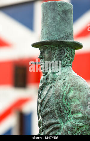 Statue von Isambard Kingdom Brunel mit Zigarre steht vor einem Union Jack Flagge, Saltash Stockfoto