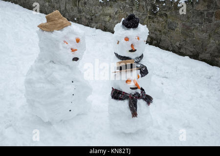 Presteigne, Powys, Wales, UK. 10. Dezember 2017. Ein starker Schneefall deckt viel von Wales einschließlich dieser kleinen walisischen Stadt. Eine Familie von Schneemännern. Kredit Alex Ramsay/Alamy leben Nachrichten Stockfoto