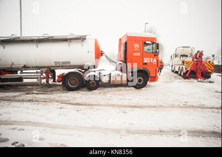 Coleford, UK. 10 Dez, 2017. UK Wetter, schweren Schnee über die Stadt. Ein Sitra Sattelschlepper durch eine Caldicot Recovery truck gerettet werden, nachdem sie auf einer vereisten Straße stecken. Credit: Tom Radford/Alamy leben Nachrichten Stockfoto