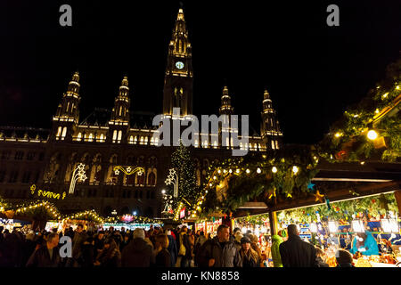 Wien, Österreich, 10. Dezember 2017. Traditionelle festliche Jahreszeit Wiener Weihnachtsmarkt im Stadtpark (Christkindlmarkt am Rathausplatz, Wiener Christkindlmarkt), der größten weihnachtlichen Markt in Wien, befindet sich das Neue Rathaus (Neues Rathaus) im Museum im Zentrum von Wien (Innere Stadt). Neues Rathaus im Hintergrund beleuchtet. Credit: Graham Prentice/Alamy Leben Nachrichten. Stockfoto