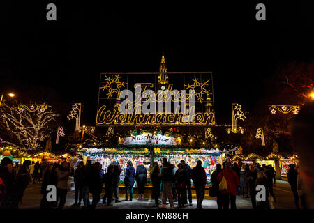 Wien, Österreich, 10. Dezember 2017. Beleuchtete Frohe Weihnachten (Frohe Weihnachten) Schild am Eingang zum traditionellen festlichen Jahreszeit Wiener Weihnachtsmarkt im Stadtpark (Christkindlmarkt am Rathausplatz, Wiener Christkindlmarkt), der größten weihnachtlichen Markt in Wien, befindet sich das Neue Rathaus (Neues Rathaus) im Museum im Zentrum von Wien (Innere Stadt). Credit: Graham Prentice/Alamy Leben Nachrichten. Stockfoto