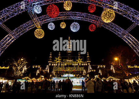 Wien, Österreich, 10. Dezember 2017. Beleuchteter Eingang arch und Frohe Weihnachten (Frohe Weihnachten) an der traditionellen festlichen Jahreszeit Wiener Weihnachtsmarkt im Stadtpark (Christkindlmarkt am Rathausplatz, Wiener Christkindlmarkt), der größten weihnachtlichen Markt in Wien, befindet sich das Neue Rathaus (Neues Rathaus) im Museum im Zentrum von Wien (Innere Stadt). Credit: Graham Prentice/Alamy Leben Nachrichten. Stockfoto