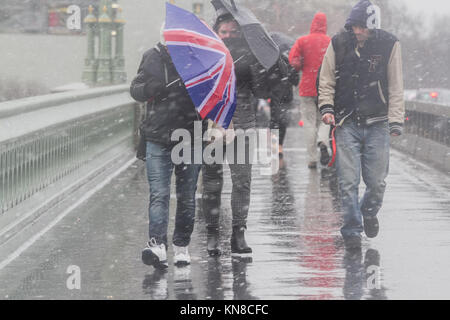 London, Großbritannien. 11 Dez, 2017. Fußgänger kämpfen mit der gefrierenden Regen und Schneeregen Bedingungen auf die Westminster Bridge fertig zu werden, da die Temperaturen unter dem Gefrierpunkt Kredit sinken: Amer ghazzal/Alamy leben Nachrichten Stockfoto