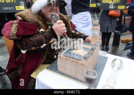 London, Großbritannien. 11. Dezember, 2017. Amnesty International und Liberty inszeniert eine "Henry VIII isst Parlament "Stunt in Westminster am Montag bedenken Menschenrechtsaktivisten' mit, wie die Regierung behandelt die Rechte der Menschen in der EU Widerrufsrecht Rechnung zu markieren. Die Bremsung wird ein voll-kostümierten Henry VIII Imitator serviert wird und teilweise aufwendig eine riesige Häuser des Parlaments Kuchen. Der Kuchen, durch eine spezialisierte London Bäckern angefertigt, wird die berühmt-big-Appetit König serviert werden. Stockfoto