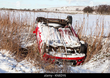 Beeley beeley Lane, Moor, Derbyshire, Großbritannien 11. Dezember 2017. Schnee bedeckten Straßen und Temperaturen unter dem Gefrierpunkt machen das Fahren gefährlich Beeley Moor im Peak District, wo eine kleine Limousine links die Straße und kommt auf seinem Dach zu Rest umgeworfen. Credit: Mark Richardson/Alamy leben Nachrichten Stockfoto