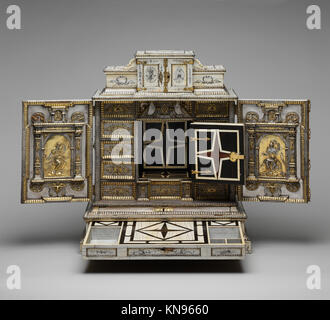 Dieser deutsche Schrank aus dem 17. Jahrhundert ist mit aufwändigen Gravuren, silbernen Tafeln, vergoldeten Befestigungen und seidenbeschichteten Schubladen ausgestattet, die feine Handwerkskunst und dekorative Kunst demonstrieren. Stockfoto