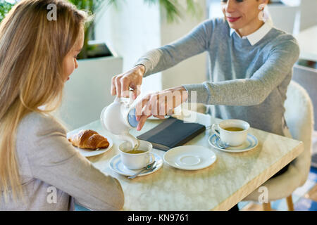 Zwei junge Frauen genießen das Frühstück im Cafe Stockfoto