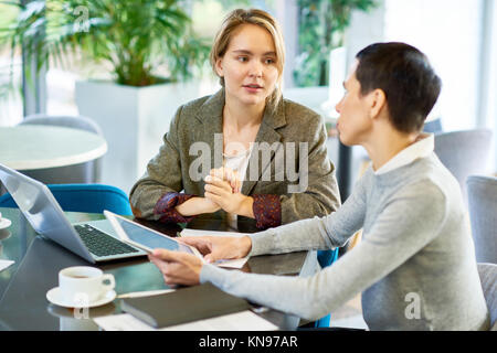 Blonde junge Frau diskutieren Projekt mit Chef Stockfoto