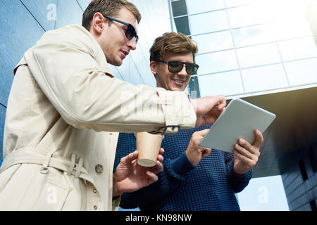 Zwei Männer mit Tablet im Sonnenlicht Stockfoto