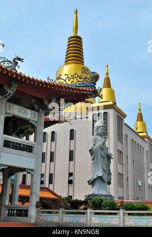 Buddhistische Statue mit goldene Pagode im Hintergrund. In Singapur. Ein Symbol der Religion, des Glaubens, des Kultes und Gelassenheit. Stockfoto