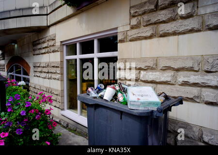 Mülltonne überfüllt mit Flaschen und Dosen außerhalb einer Kneipe in Islington, London, England Stockfoto