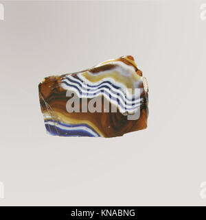 Ein geripptes Glasmosaik-Schälfragment, das komplexe Handwerkskunst und alte dekorative Kunst hervorhebt und Design und Materialkultur widerspiegelt. Stockfoto