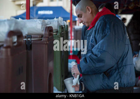 Us Marine Corps Staff Sgt. Amin Valdes, die R.G. Robinson Mess Hall Manager, gießt hot Apple Cider in eine Schale während eines Urlaubs baum Beleuchtung in der Marine Corps Air Station Iwakuni, Japan, Dez. 2, 2017. Der Baum Beleuchtung brachten japanische Einheimische und Amerikaner zusammen für einen Urlaub von der Feier. Mehrere Organisationen, die Stände Geld für ihre Sache zu heben und Live Musik gespielt, während die Marine Corps Community Services Iwakuni kostenlose Kekse und heiße Getränke für die Teilnehmer zur Verfügung gestellt. (U.S. Marine Corps Stockfoto