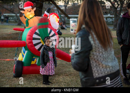 Vivian Junge, ein Bewohner auf Basis, nimmt ein Bild von ihrer Tochter, Jasmin, während eines Urlaubs baum Beleuchtung in der Marine Corps Air Station Iwakuni, Japan, Dez. 2, 2017. Der Baum Beleuchtung brachten japanische Einheimische und Amerikaner zusammen für einen Urlaub von der Feier. Mehrere Organisationen, die Stände Geld für ihre Sache zu heben und Live Musik gespielt, während die Marine Corps Community Services Iwakuni kostenlose Kekse und heiße Getränke für die Teilnehmer zur Verfügung gestellt. (U.S. Marine Corps Stockfoto