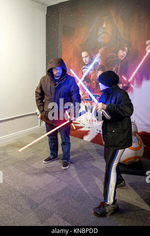 Star Wars Fans spielen mit lichtschwertern vor einem Plakat der Star Wars Der letzte Jedi im Kontextmenü des Film-up Stores in der Innenstadt von Toronto, Kanada. Stockfoto