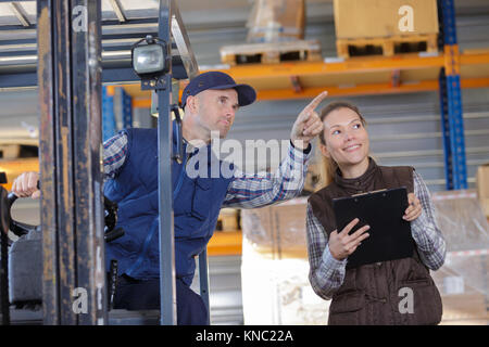 Manager im Gespräch mit seinem Mitarbeiter im Lager Stockfoto
