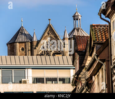 Die alte Fassade der Kathedrale hinter einem neuen Kaufhaus in Braunschweig, Deutschland mit Häuser der Altstadt vor. Stockfoto