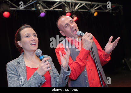 Paar auf der Bühne singen mit Mikrofonen Stockfoto