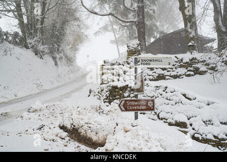 Snowshill Ortsschild im Schnee im Dezember. Snowshill, Cotswolds, Gloucestershire, England Stockfoto