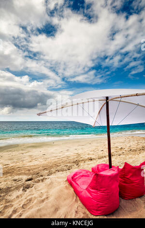 Bean Bag Stühlen und Sonnenschirm zu mieten am White Sand Beach (Pantai Bias Putih). Manggis Kleinstadt Regency, Karangasem, in Bali, Indonesien. Stockfoto