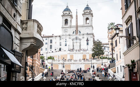 Rom, Italien, November 2017: Touristen saßen auf der Spanischen Treppe, Scalinata di Trinità dei Monti, einem der berühmtesten Treppenhäuser in Welt oberhalb der Piazza di Spagna und der Kirche Santissima Trinità dei Monti. Stockfoto