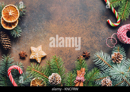 Traditionelle Weihnachten Hintergrund mit Fir Tree Branch, Zuckerstange, Tannenzapfen, getrockneten Früchten und Lebkuchen Cookie. Kopieren Sie Platz für Text Stockfoto