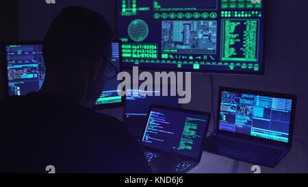 Männliche Hacker arbeiten auf einem Computer in einem dunklen Büro Zimmer. Stockfoto