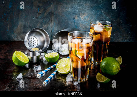 Cuba Libre, Long Island oder Eistee Cocktail mit starken Alkohol, Cola, Kalk und Eis, zwei Glas, dunklen Hintergrund Kopie Raum Stockfoto
