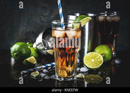 Cuba Libre, Long Island oder Eistee Cocktail mit starken Alkohol, Cola, Kalk und Eis, zwei Glas, dunklen Hintergrund Kopie Raum Stockfoto
