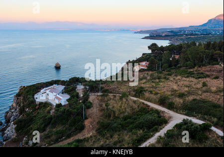 Dämmerung Blick auf schöne Tyrrhenische Meer Bucht und die Faraglioni di Scopello von oben, Provinz Trapani, Sizilien, Italien. Stockfoto