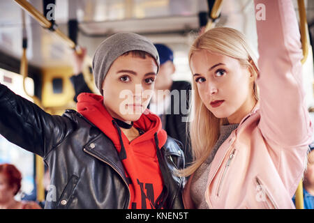 Zwei junge Frauen, die auf die Straßenbahn stehend Stockfoto
