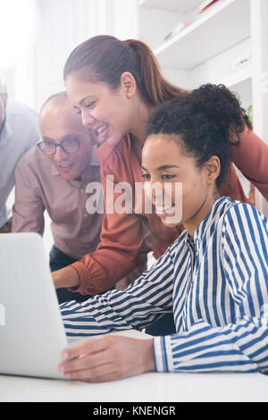 Geschäftsfrauen und Männer an Laptop am Konferenztisch suchen Stockfoto