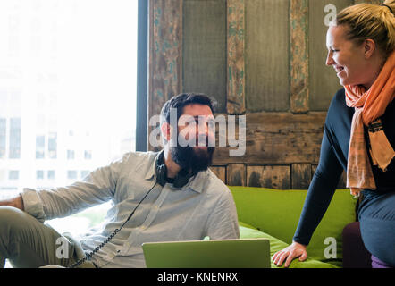 Kollegen mit Laptop sofa chatten Stockfoto