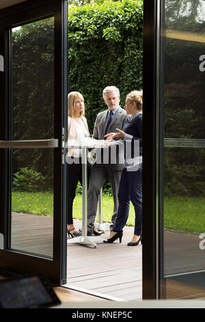 Blick durch die Tür der Kollegen am Tisch stehen Erfrischungen genießen. Stockfoto