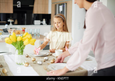 Mädchen und Mutter vorbereiten, Einstellungen zu Ostern Esstisch Stockfoto