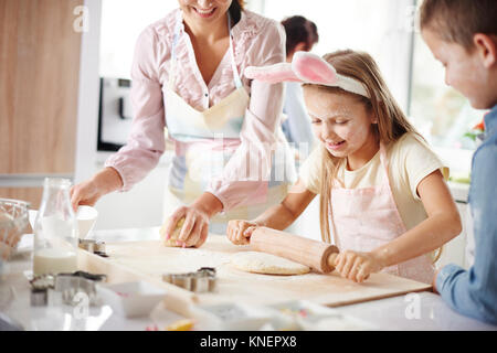 Mädchen mit Mutter und Bruder Ostern Backen an den Küchentisch Stockfoto