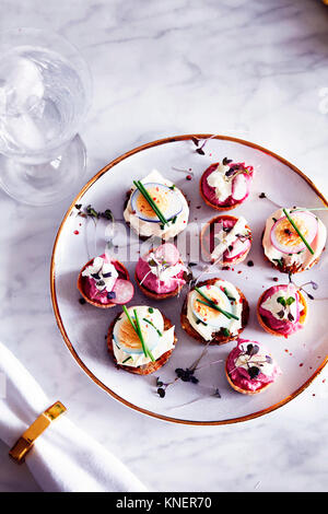 Wachtel Ei und Ziegenkäse Canapés auf Platte, Ansicht von oben Stockfoto