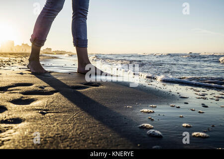 Beine von barfüßigen Frau, im Water's Edge am Strand, Riccione, Emilia-Romagna, Italien Stockfoto