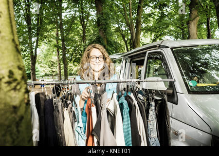 Portrait von weiblichen Halter Abschaltdruck durch Second Hand Kleidung Rampe Wald Flohmarkt Stockfoto